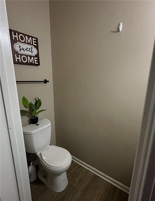 bathroom featuring baseboards, toilet, and wood finished floors