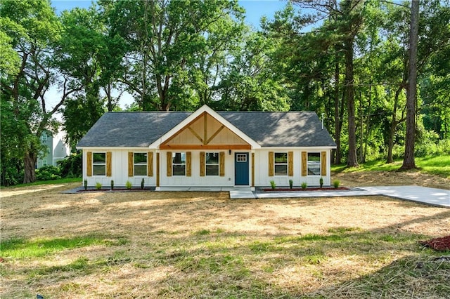 124 Sims Dr, Hiram, GA 30141 - modern farmhouse featuring a porch, board and batten siding, a front yard, and roof with shingles