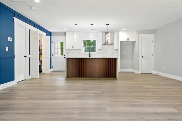 124 Sims Dr, Hiram, GA 30141 - kitchen featuring wall chimney range hood, white cabinets, recessed lighting, light wood-style floors, and baseboards