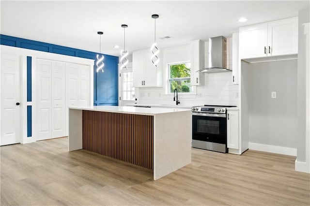 124 Sims Dr, Hiram, GA 30141 - kitchen with stainless steel electric stove, wall chimney exhaust hood, a center island, white cabinets, and recessed lighting