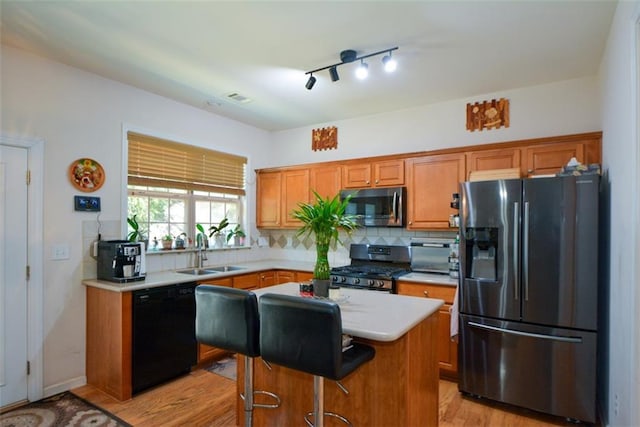 574 Friars Head Dr, Suwanee, GA 30024 - kitchen featuring stainless steel appliances, light countertops, light wood finished floors, tasteful backsplash, and brown cabinetry