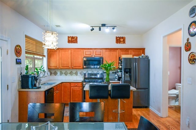 574 Friars Head Dr, Suwanee, GA 30024 - kitchen featuring appliances with stainless steel finishes, light wood-type flooring, decorative backsplash, brown cabinetry, and light countertops