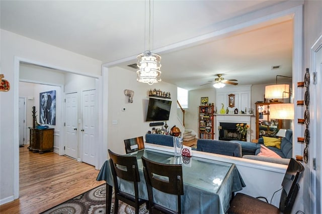574 Friars Head Dr, Suwanee, GA 30024 - dining space with wood finished floors, a fireplace, and a ceiling fan