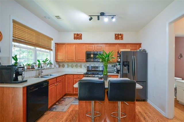 574 Friars Head Dr, Suwanee, GA 30024 - kitchen with appliances with stainless steel finishes, light wood-style floors, light countertops, decorative backsplash, and a kitchen island