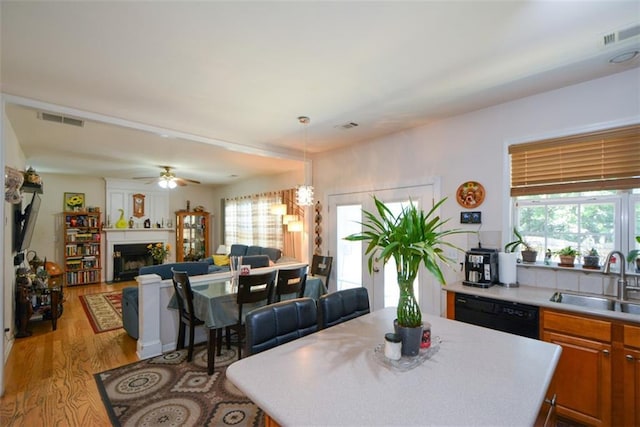 574 Friars Head Dr, Suwanee, GA 30024 - dining area with light wood-style flooring, healthy amount of natural light, a ceiling fan, and a fireplace