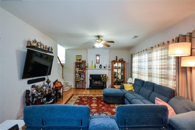 574 Friars Head Dr, Suwanee, GA 30024 - living room with wood finished floors, a fireplace, a ceiling fan, and stairs