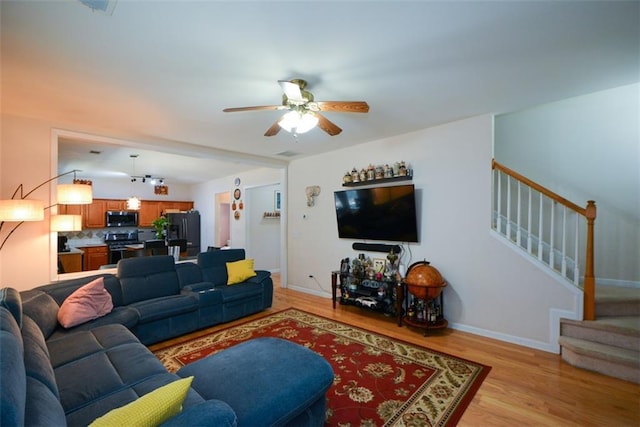 574 Friars Head Dr, Suwanee, GA 30024 - living room featuring stairs, a ceiling fan, and light wood-style flooring