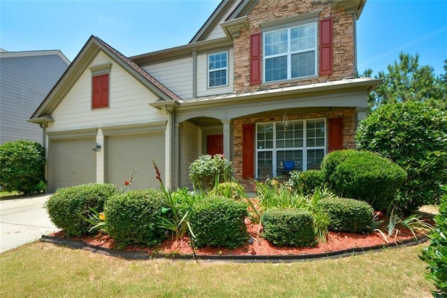 574 Friars Head Dr, Suwanee, GA 30024 - craftsman-style home with stone siding, a porch, concrete driveway, and an attached garage