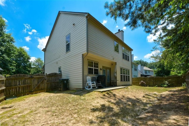 574 Friars Head Dr, Suwanee, GA 30024 - rear view of property with a chimney, a fenced backyard, a patio area, and a gate