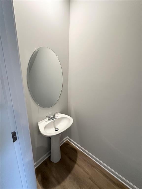 bathroom with baseboards and wood finished floors