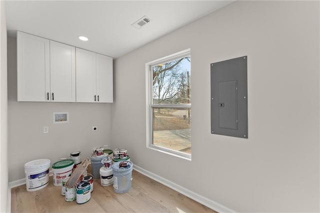 laundry area with light hardwood / wood-style flooring, electric dryer hookup, electric panel, cabinets, and washer hookup