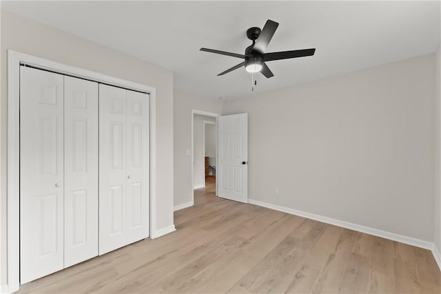 unfurnished bedroom with ceiling fan, light wood-type flooring, and a closet