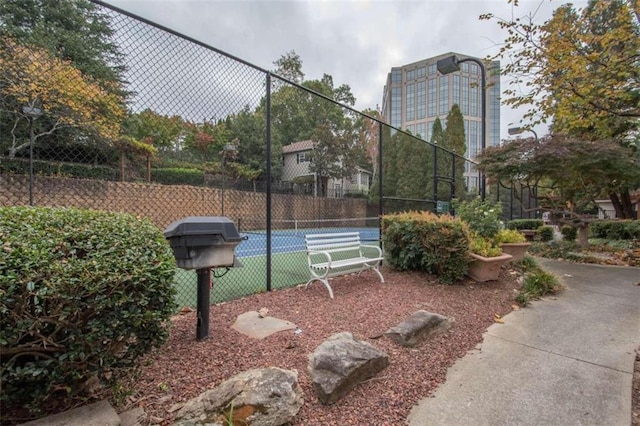 view of home's community featuring tennis court