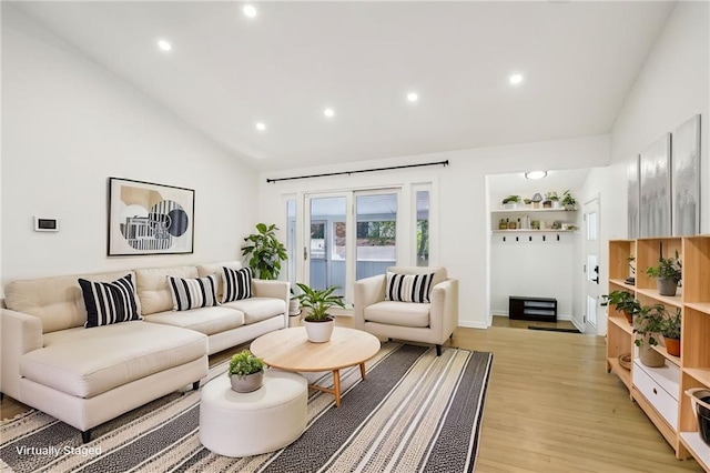 living area featuring light wood-style flooring, high vaulted ceiling, and recessed lighting