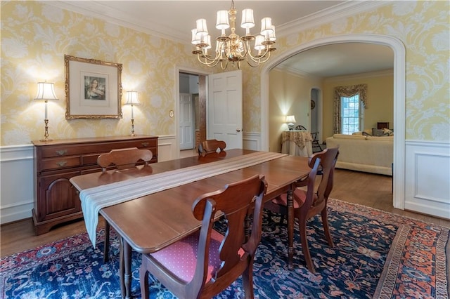 335 Cameron Ridge Dr, Atlanta, GA 30328 - dining area with wood finished floors, ornamental molding, an inviting chandelier, arched walkways, and wallpapered walls
