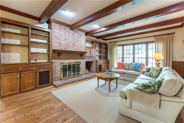 335 Cameron Ridge Dr, Atlanta, GA 30328 - living area with a wainscoted wall, beam ceiling, a brick fireplace, and light wood-type flooring