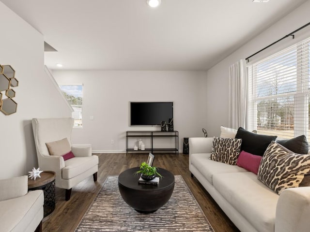 living room with plenty of natural light and dark wood-type flooring