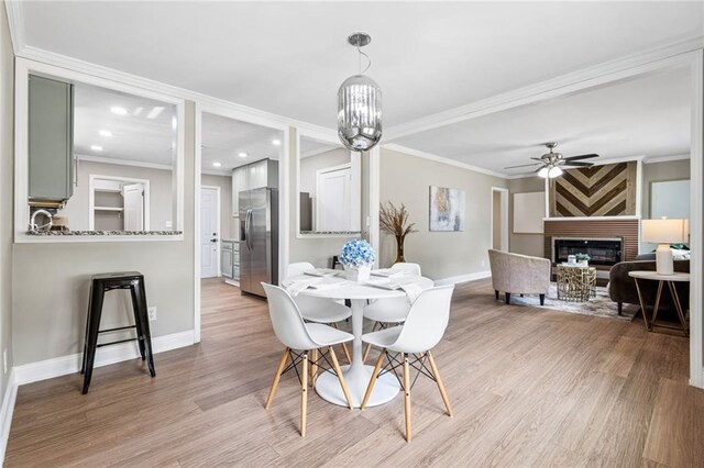 1623 Athens Ave SW, Atlanta, GA 30310 - dining space featuring light wood-style floors, ceiling fan, a fireplace, ornamental molding, and baseboards