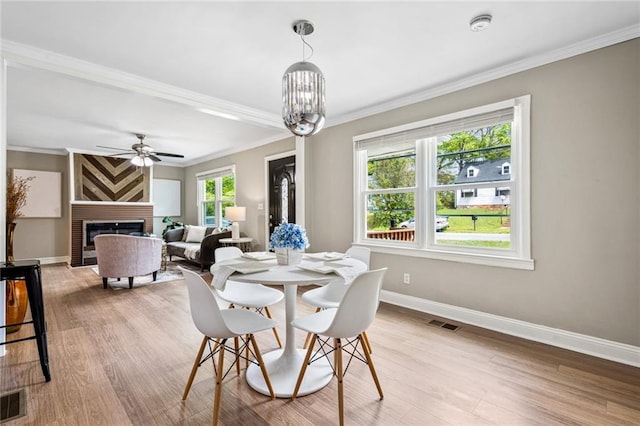 1623 Athens Ave SW, Atlanta, GA 30310 - dining area with crown molding, light wood-style flooring, a large fireplace, visible vents, and baseboards