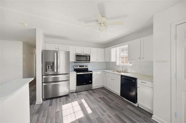 3645 Ten Oaks Cir, Powder Springs, GA 30127 - kitchen featuring stainless steel appliances, a sink, white cabinets, wood finished floors, and a textured ceiling