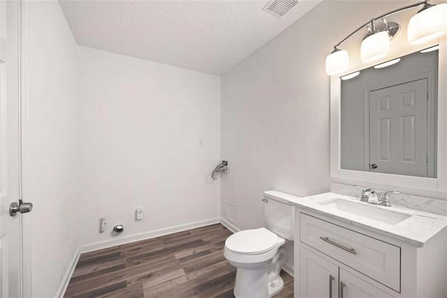 3645 Ten Oaks Cir, Powder Springs, GA 30127 - bathroom featuring toilet, a textured ceiling, vanity, wood finished floors, and baseboards