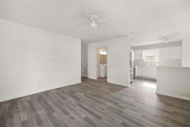 3645 Ten Oaks Cir, Powder Springs, GA 30127 - unfurnished living room with a ceiling fan, wood finished floors, baseboards, a sink, and a textured ceiling