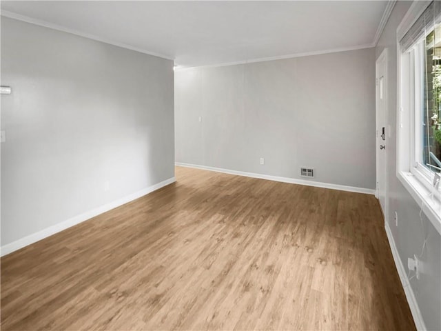 empty room with light wood-type flooring and ornamental molding