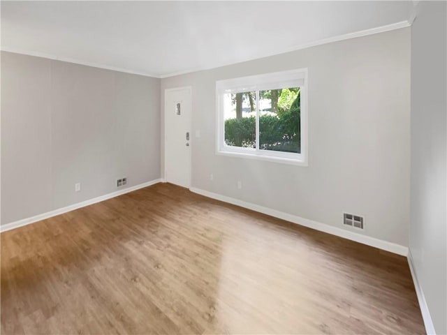 empty room featuring hardwood / wood-style flooring and crown molding