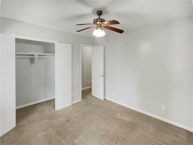 unfurnished bedroom with light carpet, a closet, and ceiling fan