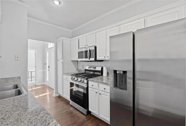 4021 Melvin Dr SW, Atlanta, GA 30331 - kitchen featuring appliances with stainless steel finishes, ornamental molding, white cabinetry, dark wood-style flooring, and light stone countertops