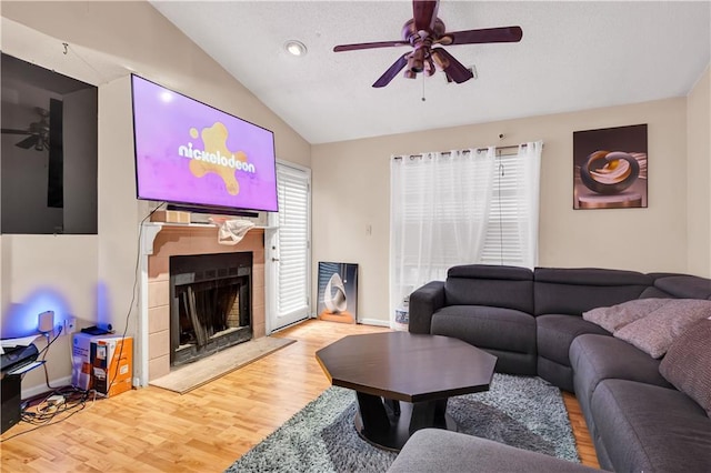 living room with ceiling fan, hardwood / wood-style floors, and vaulted ceiling