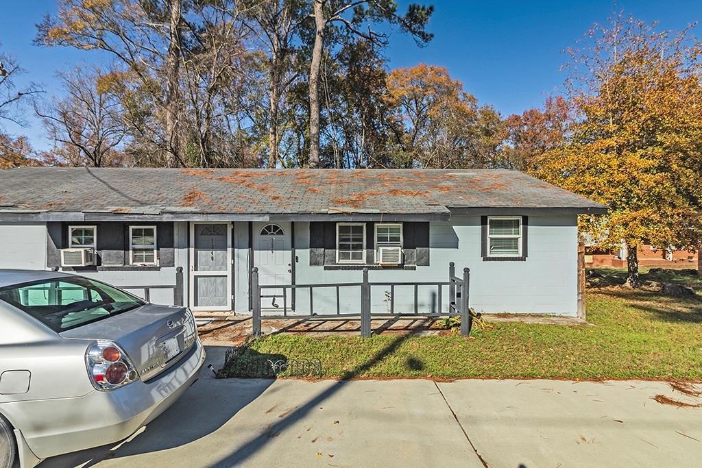 ranch-style home featuring a front yard, a porch, and cooling unit