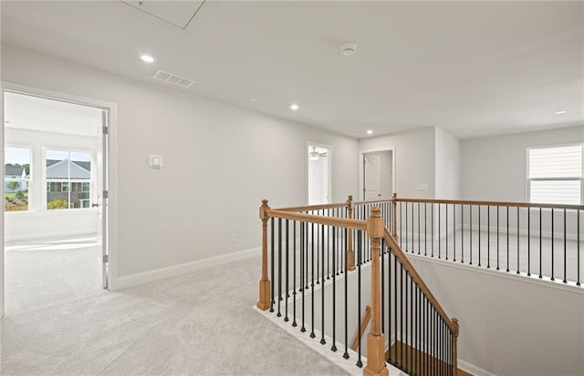 hallway featuring light colored carpet