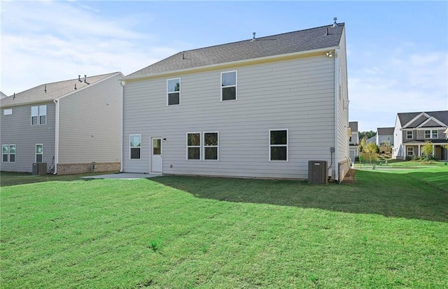 rear view of house featuring cooling unit and a lawn