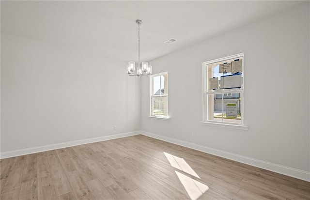 unfurnished room with light hardwood / wood-style flooring and an inviting chandelier