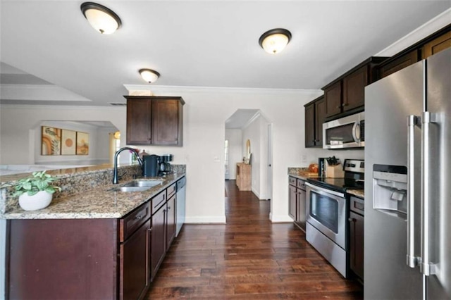 kitchen with appliances with stainless steel finishes, light stone countertops, dark hardwood / wood-style floors, ornamental molding, and sink