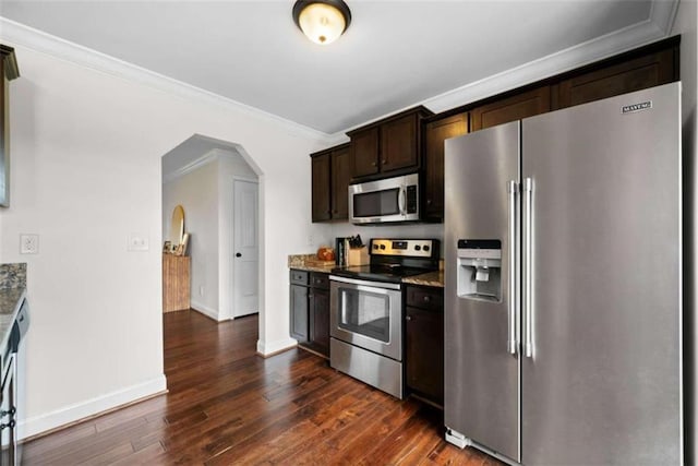 kitchen featuring dark stone countertops, dark brown cabinets, appliances with stainless steel finishes, and dark hardwood / wood-style flooring