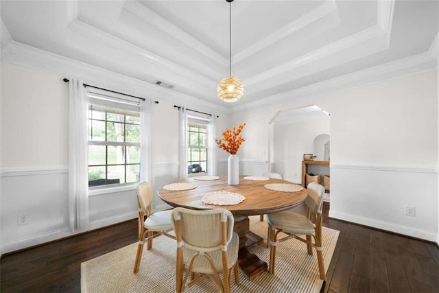 dining room featuring crown molding, a tray ceiling, and dark hardwood / wood-style flooring