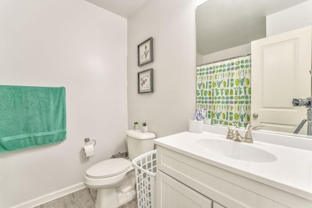 bathroom featuring vanity, wood-type flooring, and toilet