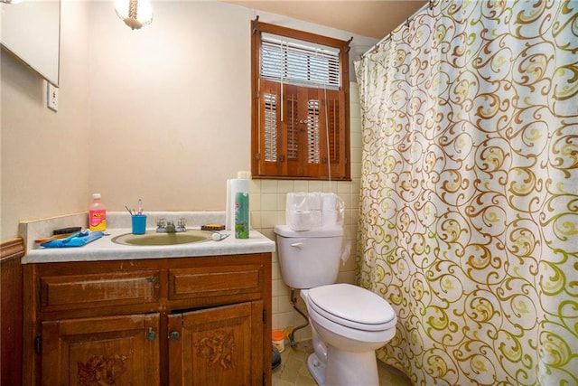 bathroom featuring tile patterned floors, toilet, vanity, and tasteful backsplash