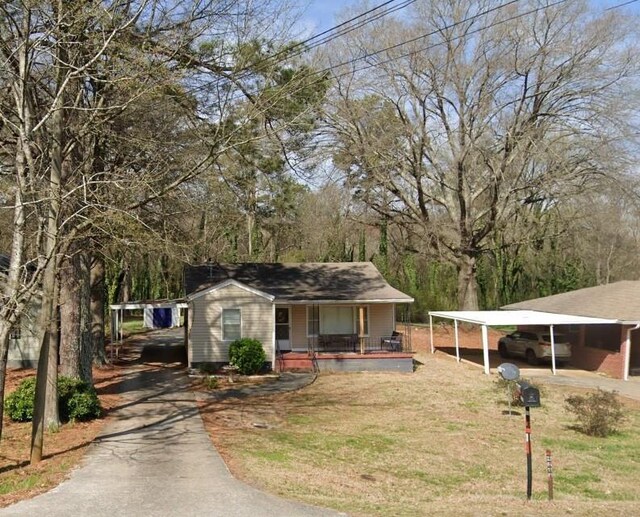 view of front facade with a front lawn, a carport, and covered porch