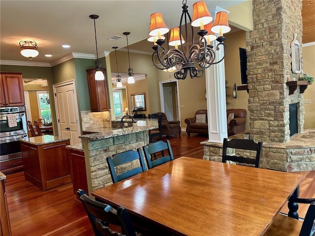 3397 Holly Glen Dr, Dacula, GA 30019 - dining area featuring a fireplace, visible vents, an inviting chandelier, and dark wood finished floors