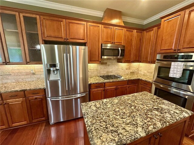 3397 Holly Glen Dr, Dacula, GA 30019 - kitchen with appliances with stainless steel finishes, light stone counters, ornamental molding, and brown cabinetry