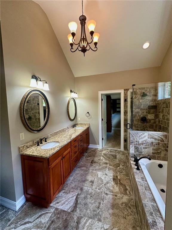 3397 Holly Glen Dr, Dacula, GA 30019 - full bathroom featuring an inviting chandelier, a sink, a bath, baseboards, and lofted ceiling