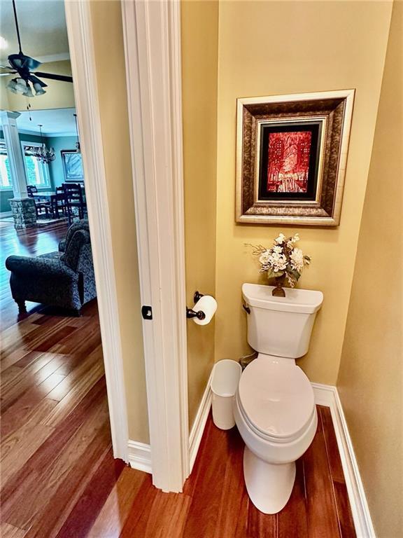3397 Holly Glen Dr, Dacula, GA 30019 - bathroom with toilet, ceiling fan with notable chandelier, wood finished floors, and baseboards