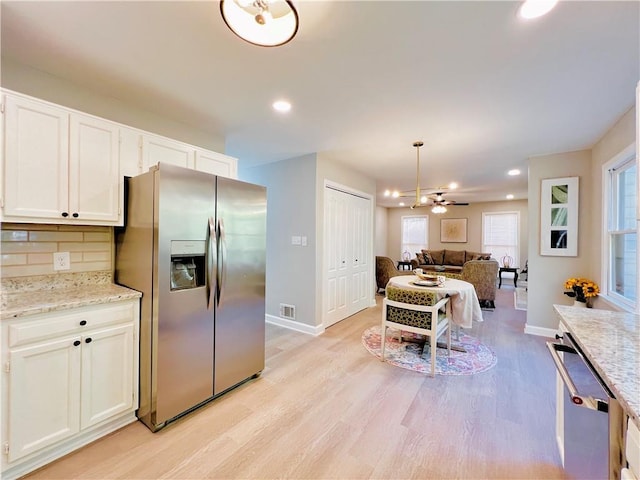 430 Thornbush Trce, Lawrenceville, GA 30046 - kitchen featuring appliances with stainless steel finishes, light wood-type flooring, tasteful backsplash, white cabinetry, and open floor plan