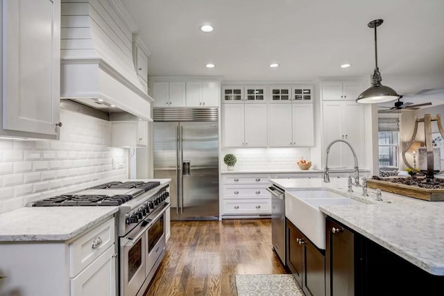 kitchen with ceiling fan, dark wood-type flooring, premium appliances, decorative light fixtures, and white cabinets