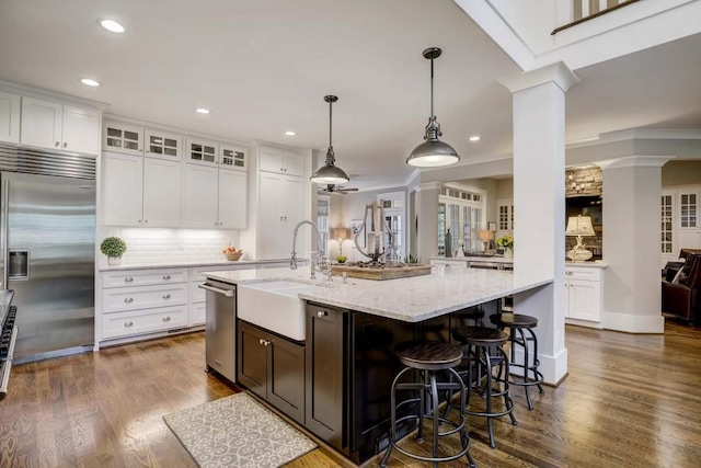 kitchen with white cabinetry, dark wood-type flooring, stainless steel appliances, tasteful backsplash, and decorative light fixtures