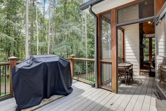 wooden deck featuring a sunroom and grilling area