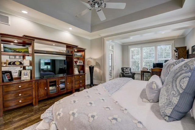 bedroom with dark hardwood / wood-style floors, a raised ceiling, and ceiling fan